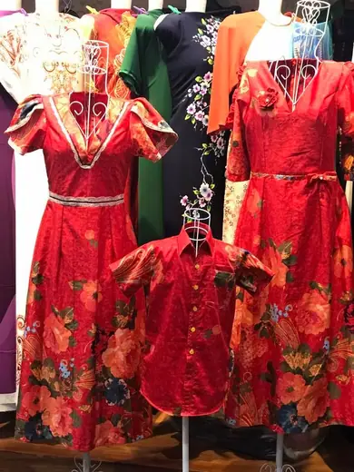Bộ váy đỏ in hoa cho mẹ và bé cùng áo sơ mi đỏ trẻ em trên ma-nơ-canh.