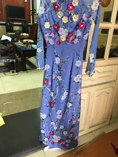 Áo dài xanh tím nhạt đính hoa nổi treo trên móc.