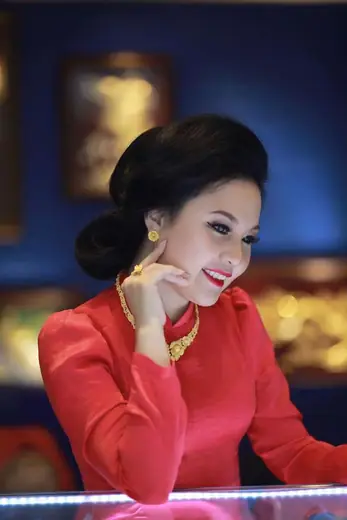 Chân dung một phụ nữ mặc áo dài đỏ, đeo trang sức vàng.