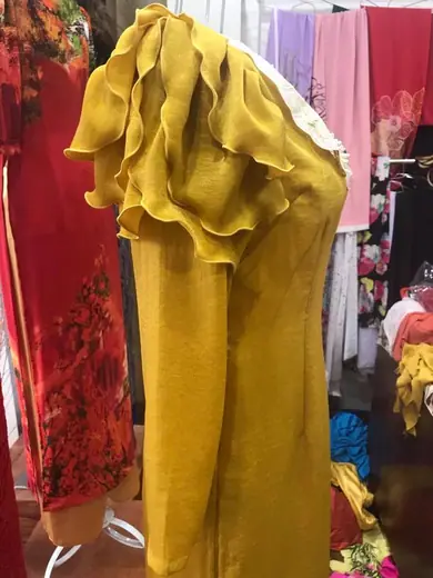 Cận cảnh tay áo dài vàng mù tạt xếp tầng như cánh hoa.