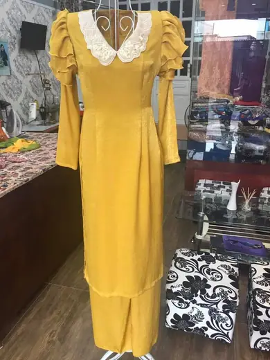 Áo dài vàng mù tạt tay cánh hồng trên ma-nơ-canh.
