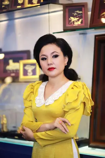 Chân dung một phụ nữ mặc áo dài vàng mù tạt tay cánh hồng.