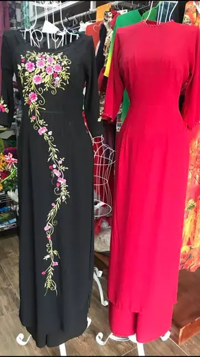 Áo dài đen thêu hoa và áo dài hồng sen trên ma-nơ-canh.