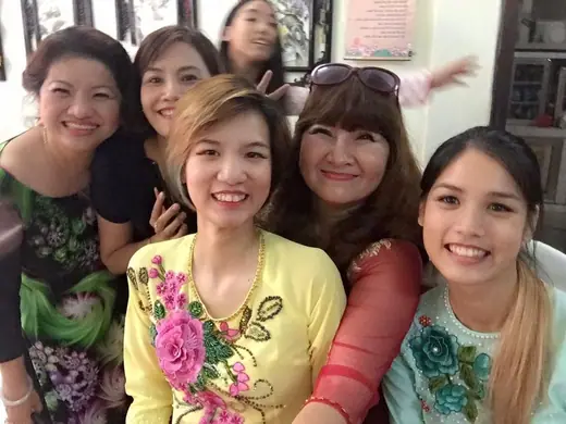 Nhóm phụ nữ mặc áo dài thêu hoa chụp ảnh tự sướng.