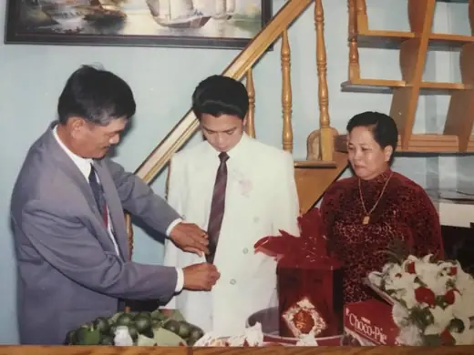 Ảnh cũ: hai người đàn ông mặc vest và một phụ nữ mặc áo dài gấm trong lễ cưới.