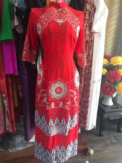Áo dài cách tân đỏ hoạ tiết trên ma-nơ-canh trong tiệm.