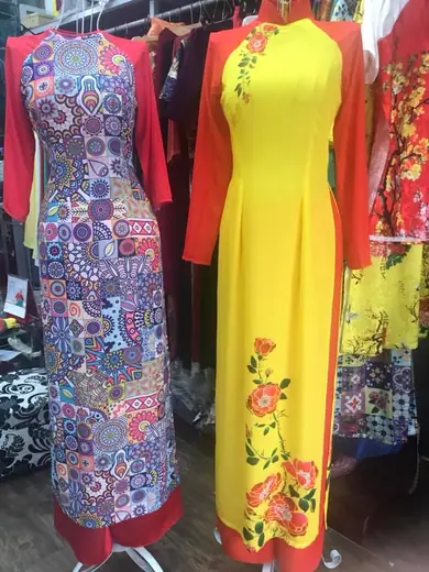 Áo dài in hoạ tiết nhiều màu và áo dài vàng vẽ hoa trên ma-nơ-canh.