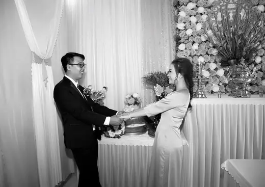 Ảnh đen trắng: cô dâu chú rể bên bàn lễ.