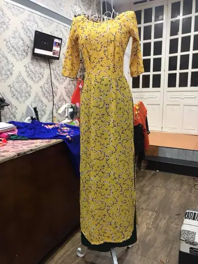 Áo dài ren vàng hoa nhí trên ma-nơ-canh.