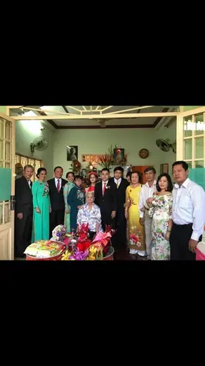 Đại gia đình mặc áo dài và vest chụp ảnh chung trong nhà.
