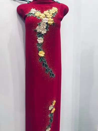 Áo dài đỏ đô kết hoa cườm vàng trên ma-nơ-canh.