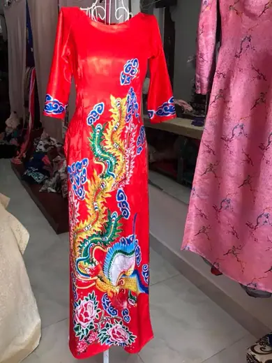 Áo dài đỏ in hình chim phượng trên ma-nơ-canh trong tiệm.