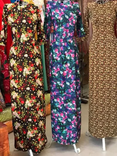 Ba chiếc áo dài in hoa nhí nền tối trên ma-nơ-canh.