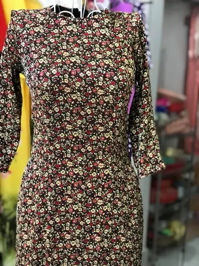 Cận cảnh áo dài in hoa nhí nền đen trên ma-nơ-canh.