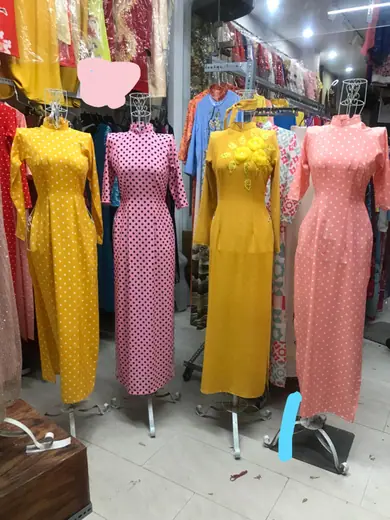 Bốn chiếc áo dài chấm bi vàng và hồng trên ma-nơ-canh.