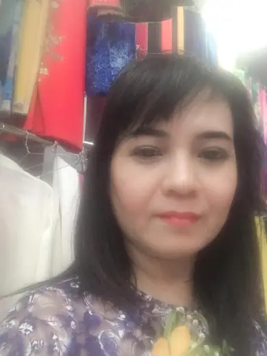 Ảnh tự chụp cận mặt của một phụ nữ mặc áo dài tím in hoa.