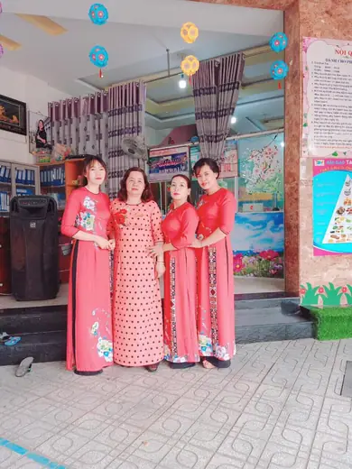 Bốn cô giáo mặc áo dài đứng trước cửa lớp.