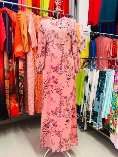 Áo dài hồng in hoa dây leo, tay phồng, trên ma-nơ-canh.