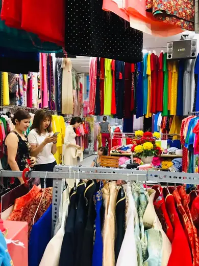 Khách đang chọn vải và thử áo trong tiệm.