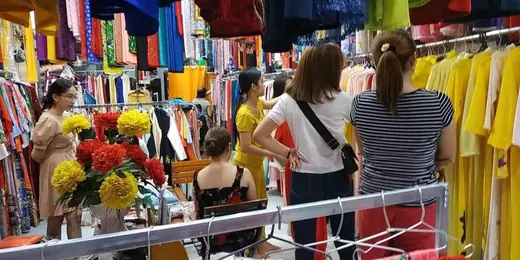 Khách đứng xem vải trong tiệm.