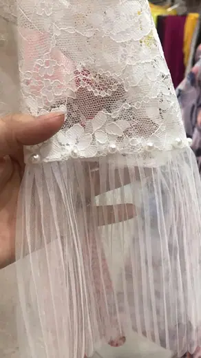 Cận cảnh tay áo ren trắng phối voan xếp ly.