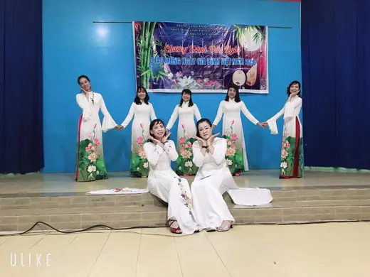 Nhóm phụ nữ mặc áo dài trắng in hoa sen biểu diễn trên sân khấu chương trình văn nghệ mừng ngày Gia đình Việt Nam.
