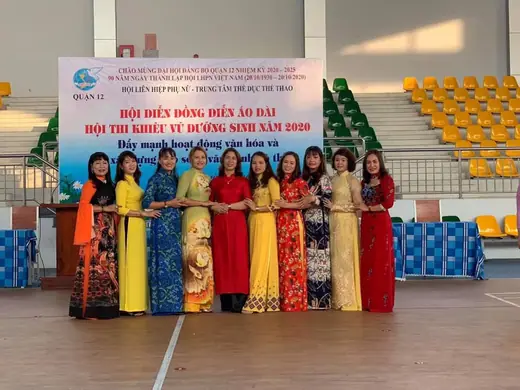 Đội phụ nữ mặc áo dài chụp chung trước băng rôn hội diễn đồng diễn áo dài năm 2020.
