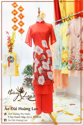 Áo dài cách tân đỏ in hoa trắng phối quần đỏ và áo trẻ em trắng, khung ảnh có tên tiệm.