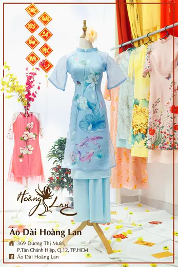 Áo dài cách tân xanh nhạt in hình cá và áo trẻ em hồng, khung ảnh có tên tiệm.