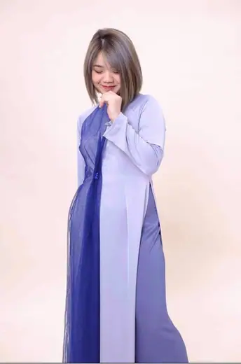 Một cô gái mặc áo dài tím nhạt phối tà xanh tím than, chụp trong phòng chụp.