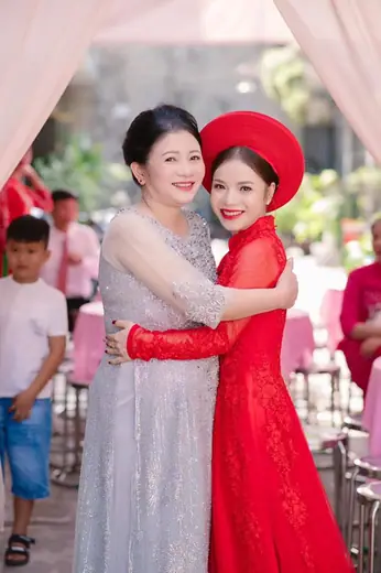 Cô dâu mặc áo dài đỏ ôm mẹ trong ngày cưới.
