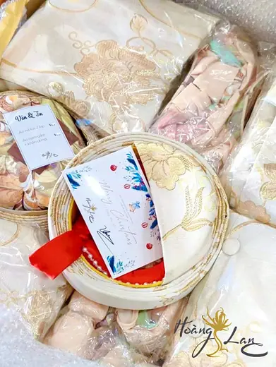 Áo dài đã đóng gói kèm thiệp và bao lì xì, ảnh có logo tiệm.