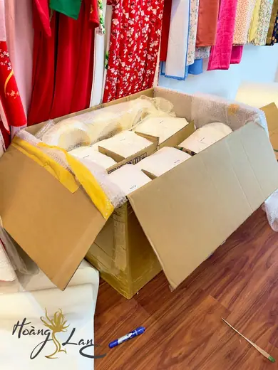 Thùng hàng chứa các hộp áo dài chuẩn bị gửi đi, đặt trong tiệm.