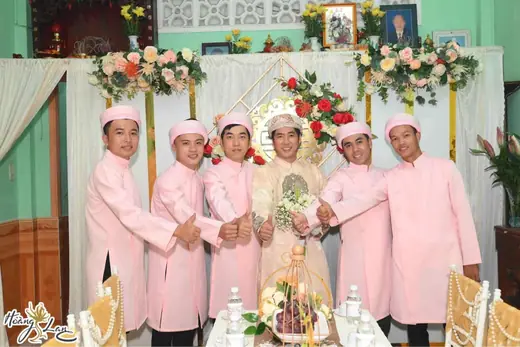 Chú rể và dàn phù rể mặc áo dài hồng, đội khăn đóng.